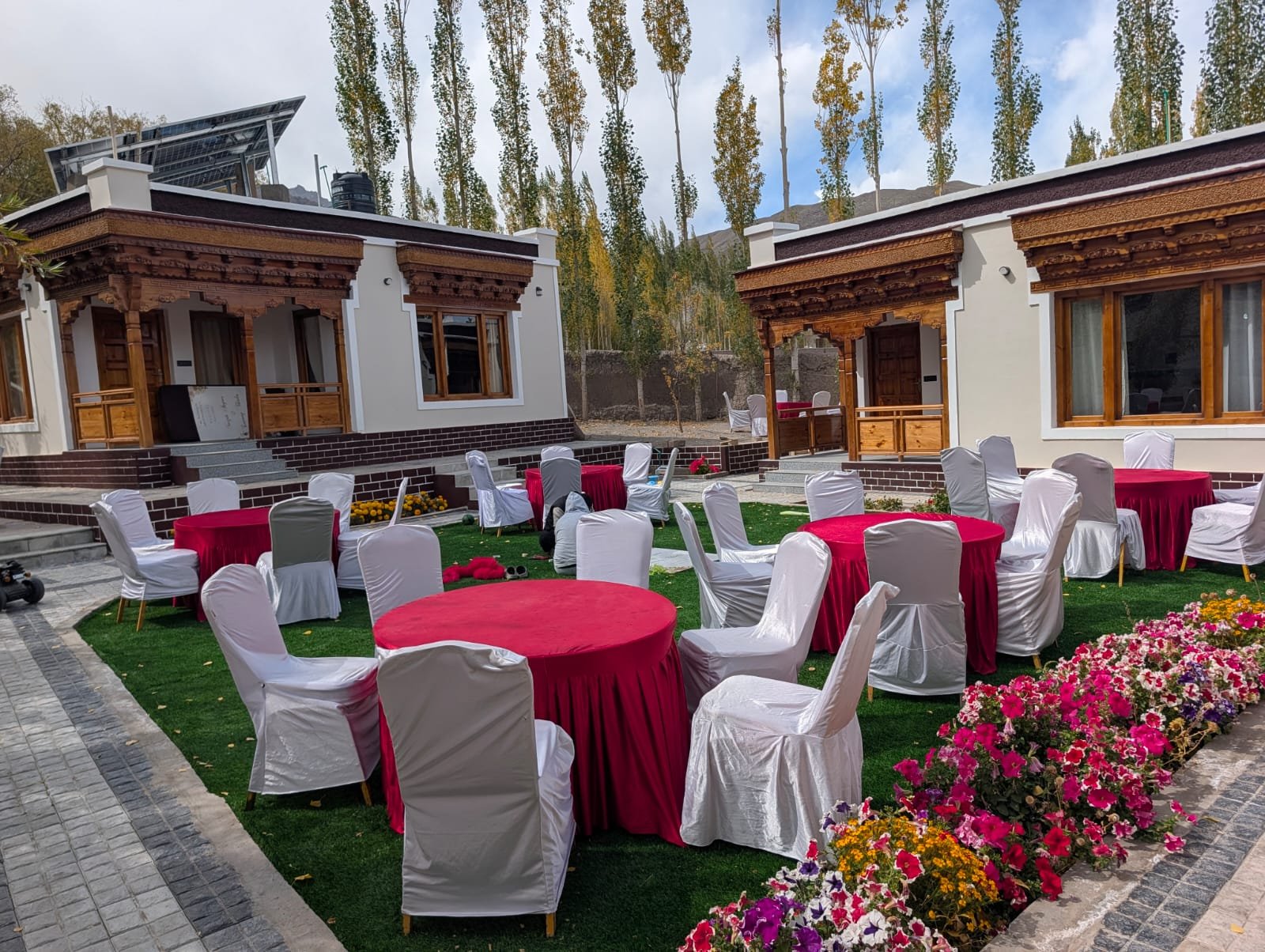 Garden dining with tables set on the lawn between the cottages