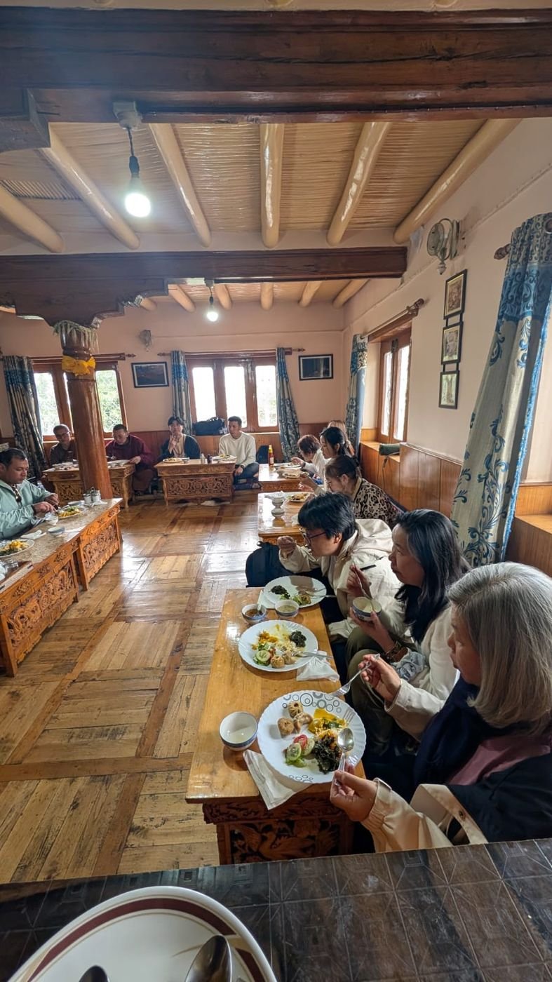 Guests at lunch in the new dining room, with wooden beams and carved tables